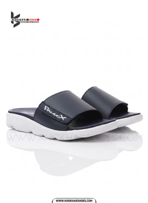 A man's feet in a pair of comfortable, navy blue and white, single-strap slides on a white background.