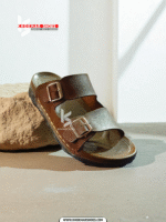 A pair of men's stylish two-strap sandals, with one in a dark brown color and the other in a deep blue-grey.