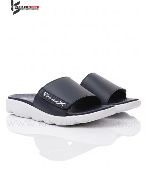 A man's feet in a pair of comfortable, navy blue and white, single-strap slides on a white background.
